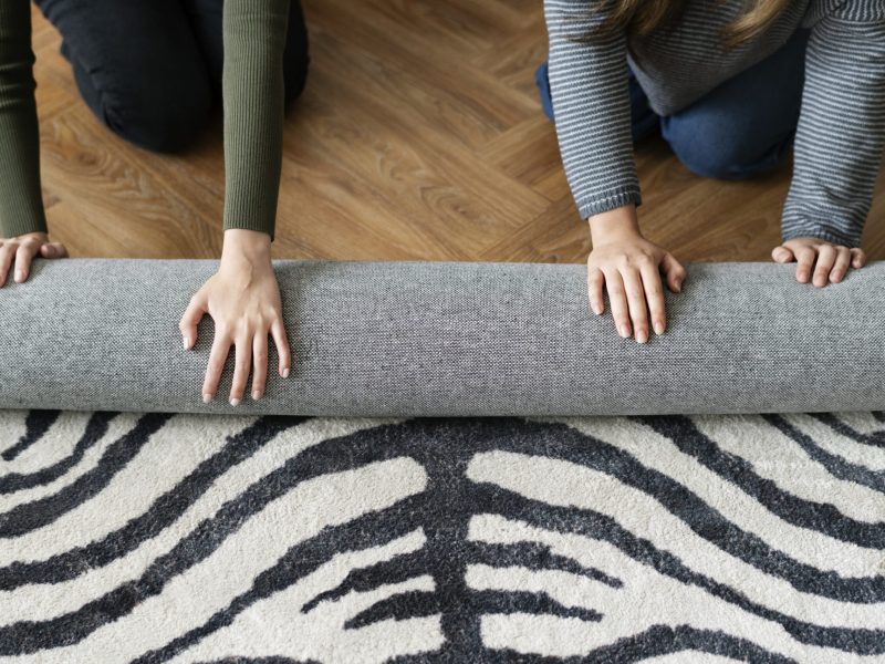 Friends rolling a carpet